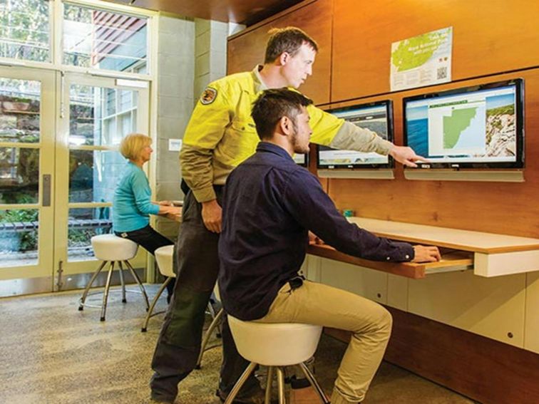 NPWS staff and visitors using the computers at Royal National Park Visitor Centre, Royal National