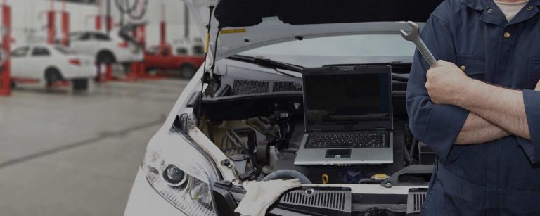 Mechanic leaning on car in workshop