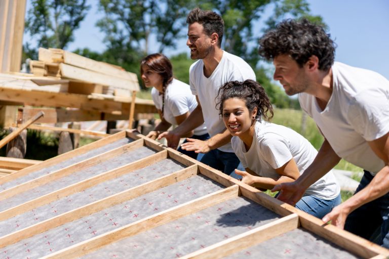 A group of people lifting up building material