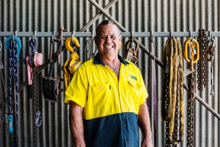 Worker smiling in shed with tools