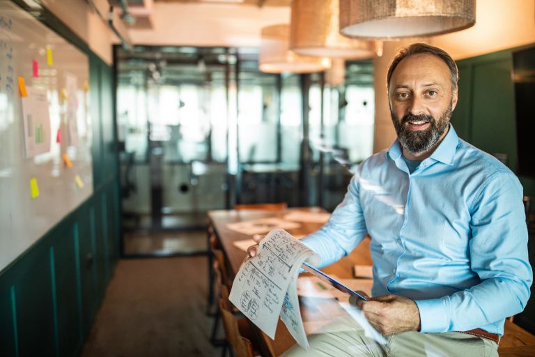 Man in office in blue shirt with paperwork