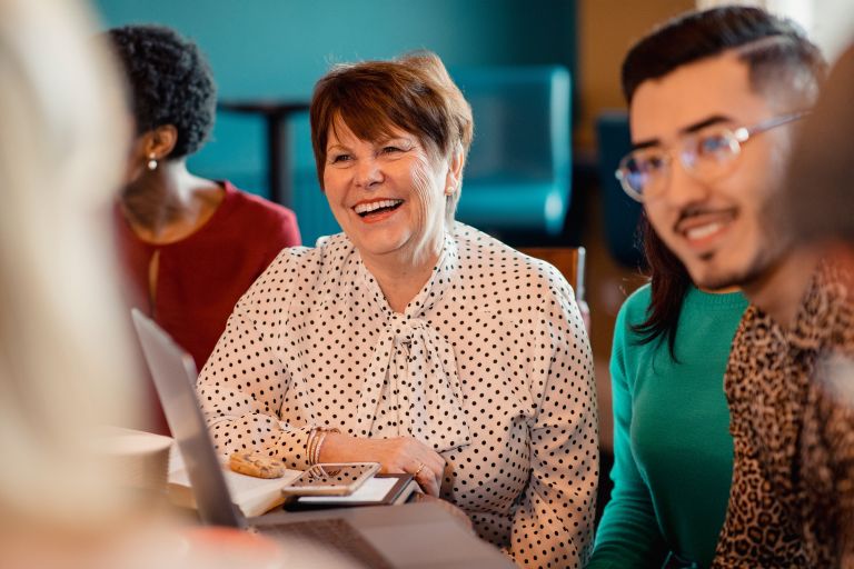 Woman serving on a committee, smiling while talking to other people