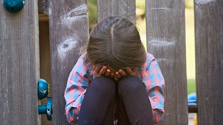 Child sitting with head in hands