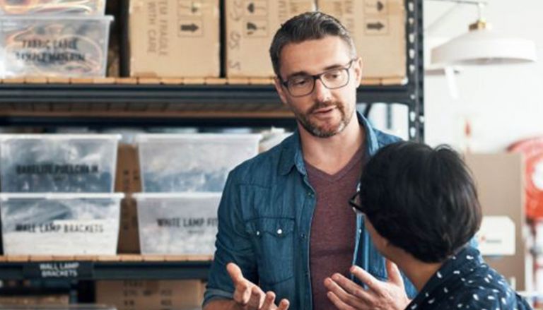 Two coworkers talking in warehouse