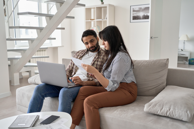 Man and woman paying bills on a laptop