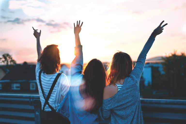 Three young people looking at a sunrise