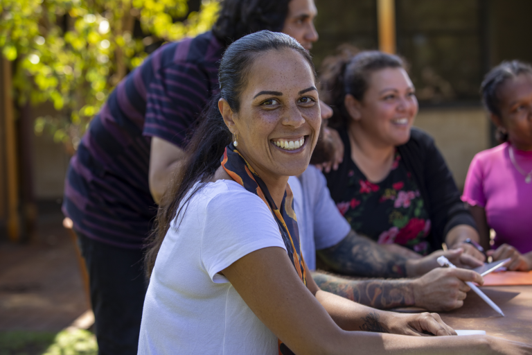 Woman smiling sitting with a group