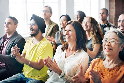 Diverse audience clapping and smiling