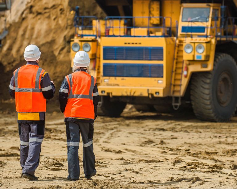 Two miners looking at equipment