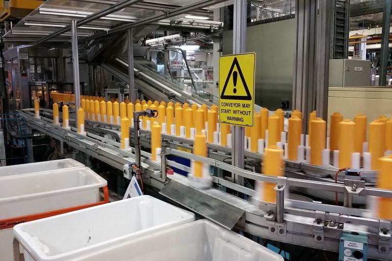 A conveyor belt with shampoo bottles made with 20 percent recycled plastic.