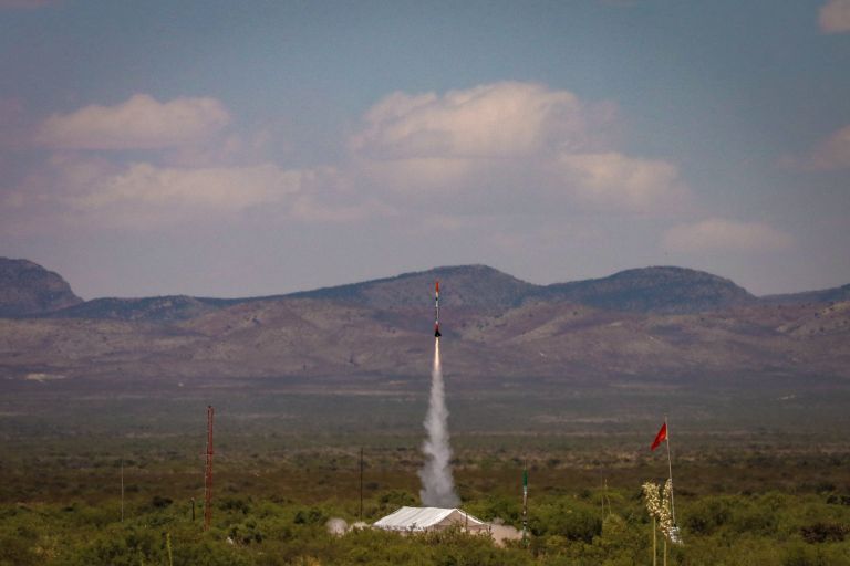 Rocket taking off against a landscape