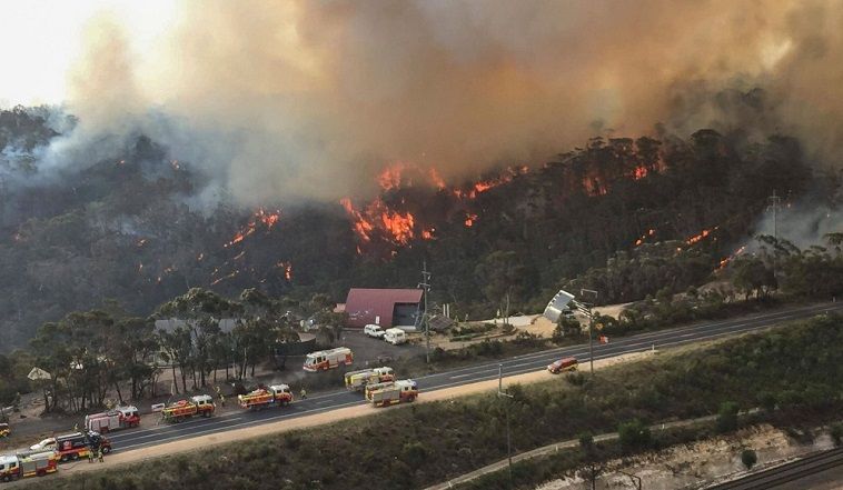 aerial view of bushfire with fire engines attending