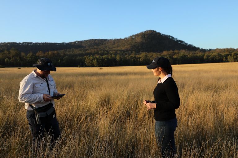 A photo of a landholder and an officer in a field as part in a site inspection for the Conservation Partners Grant.