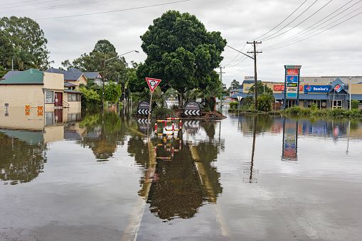 View of submerged streets including roundabout, shops, pizza places surrounded by water