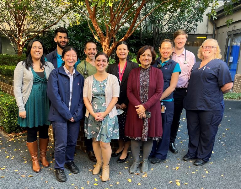 Group of smiling staff researchers near a garden