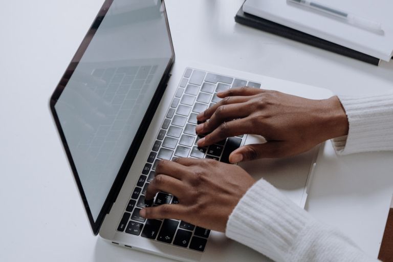 Hands typing on a laptop