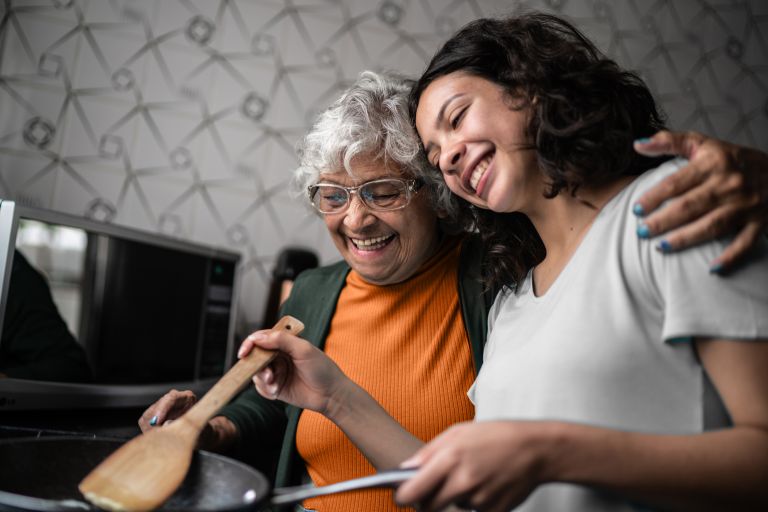 Senior women with younger women cooking together