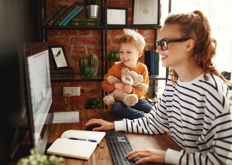 Woman at computer with young son sitting beside her