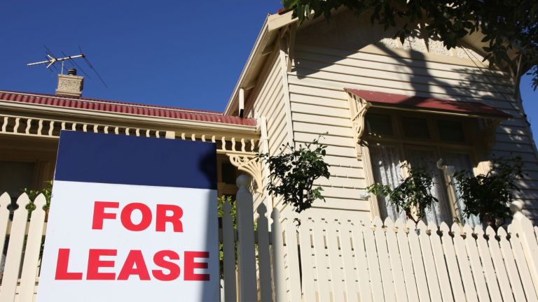 Weatherboard house with for lease sign on fence