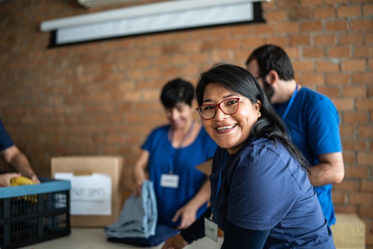 A volunteer smiles while working for a community group