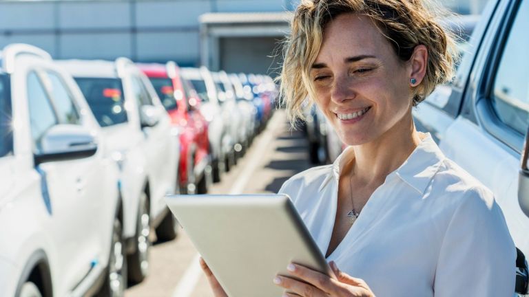 Woman stands in a car yard