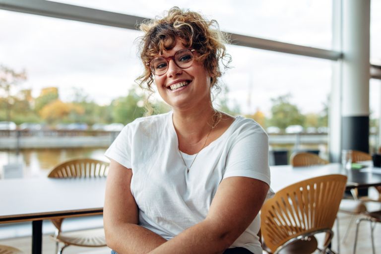 Portrait of a confident woman with eyeglasses in office.