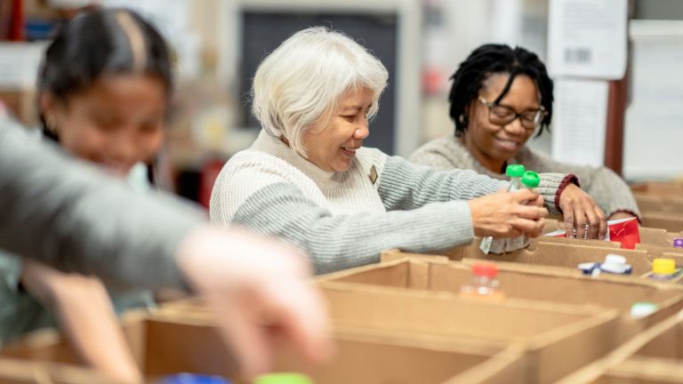 Three people packing food care boxes