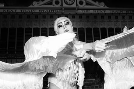 Person in theatrical makeup and white, bird-like costume