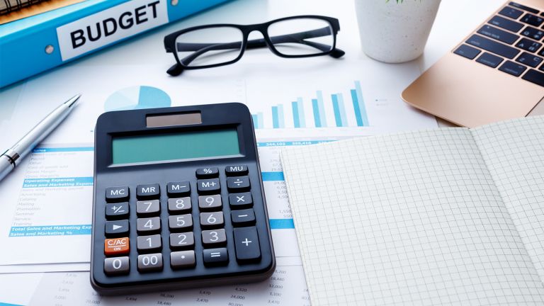 Calculator glasses and folder that says budget