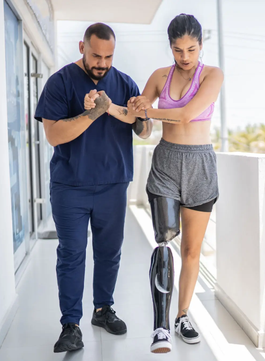 Community worker helping someone with a prosphetic leg walk