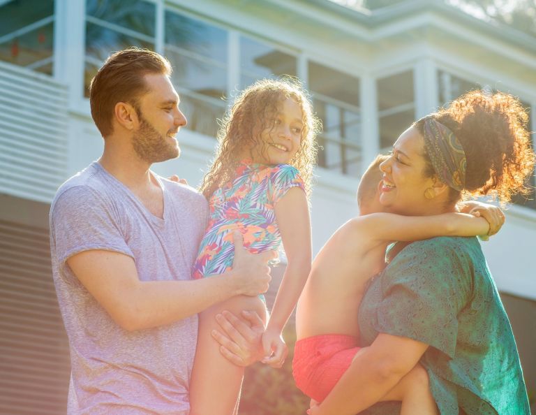 Image of two people holding children smiling