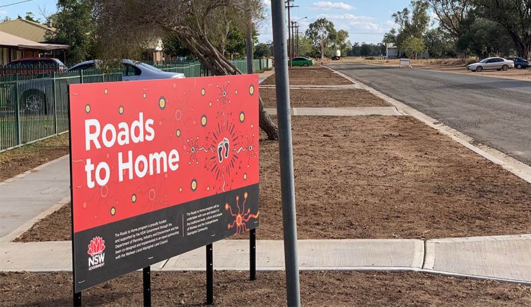 Image of a sign that reads Roads to Home