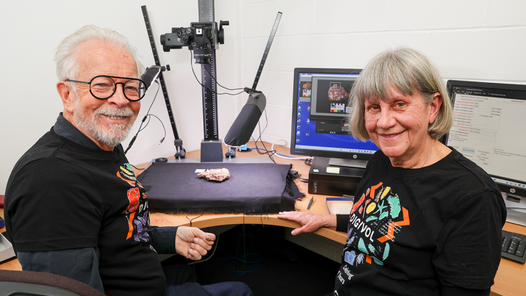 two volunteers from the Australian museum at a work station with scientific equipment