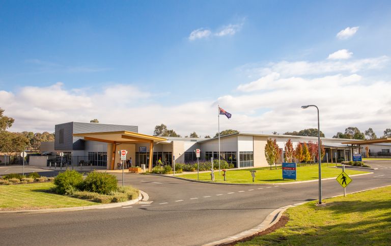 Main entry to the Junee Multipurpose Service. A sign indicating the main and emergency entry points is toward the right side of the image. The main entrance is toward the front of the image and the emergency entrance toward the back of the image. 