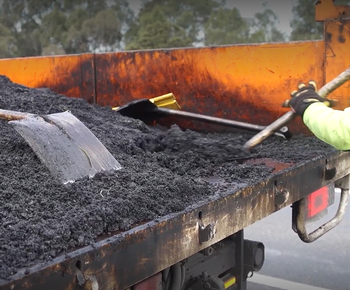 Gravel on truck to fill in pothole. 