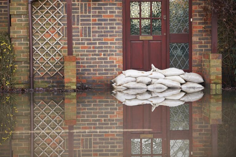 Sandbags laid against outside of front door to prevent water entering