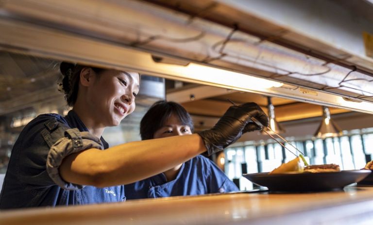 Hospitality worker placing food on plate