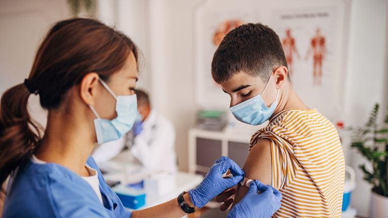 Nurse putting band aid on patient's arm