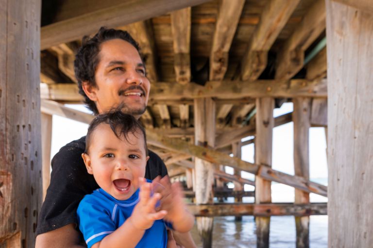 Aboriginal Australian Father and Son at the Beach - stock photo Young Indigenous Australian father and son playing at the beach