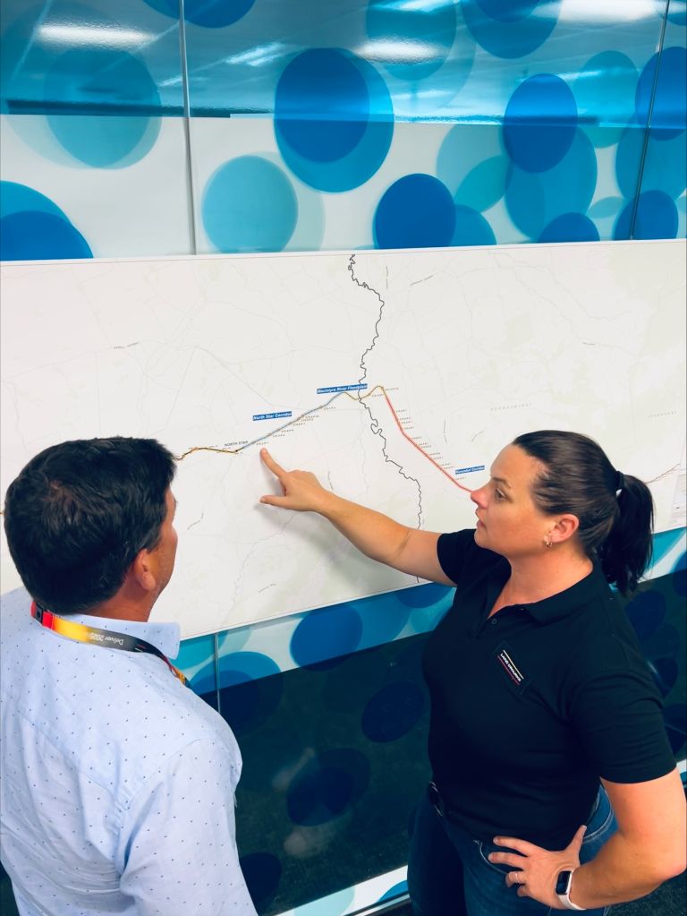 Yvonne is standing with a colleague at a whiteboard