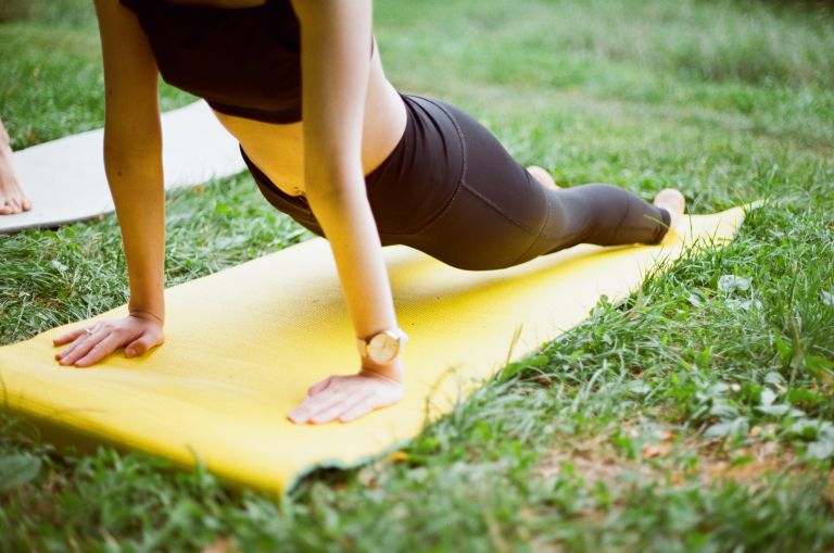 Woman on a yoga mat on the grass