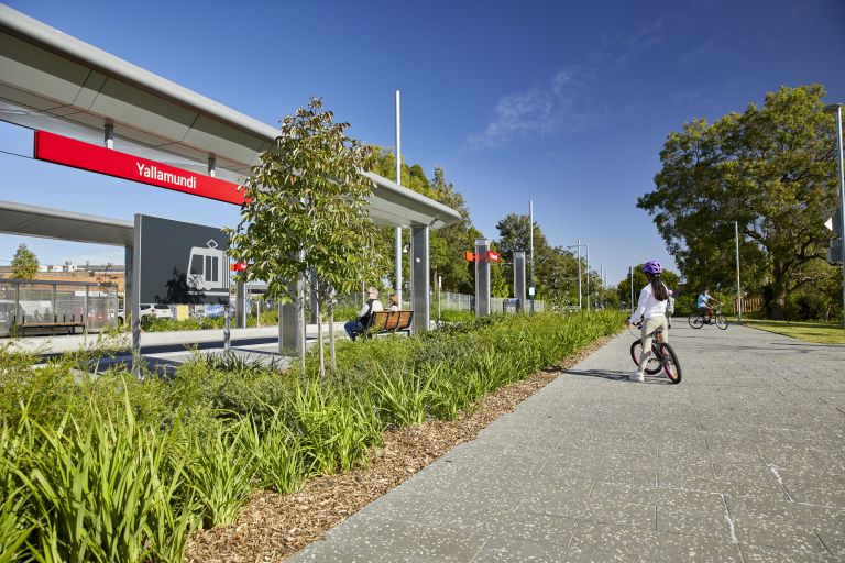 A child bike rider enjoys using the new shared pathway at Yallamundi Station on a bright, sunny day. 