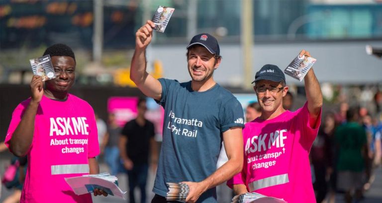 Three people with pamphlets about Parramatta Light Rail