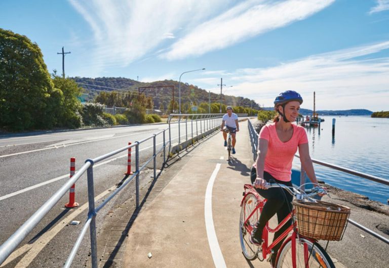 Cyclists on a shared path riding by the lake.