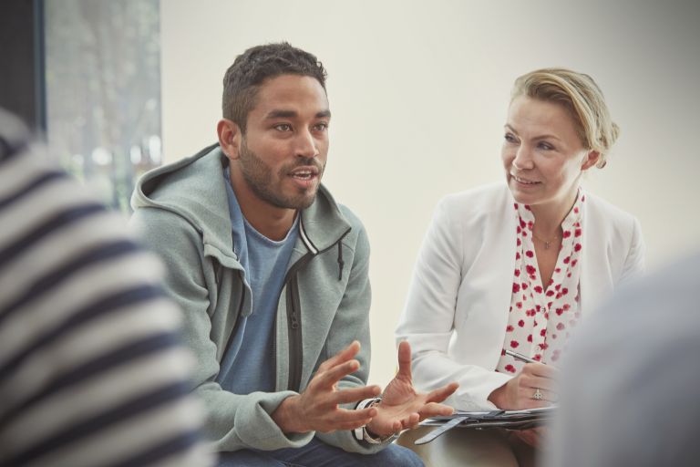 A young man talking in a group therapy session