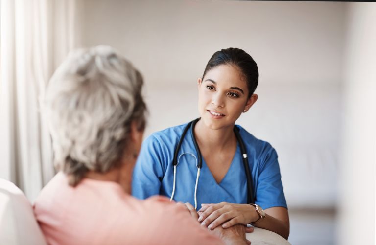 A nurse speaking to a female patient