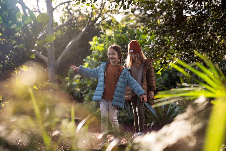 two girls in open space with trees