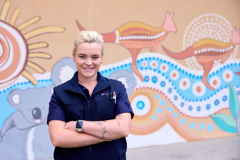 nurse smiling in front of artwork