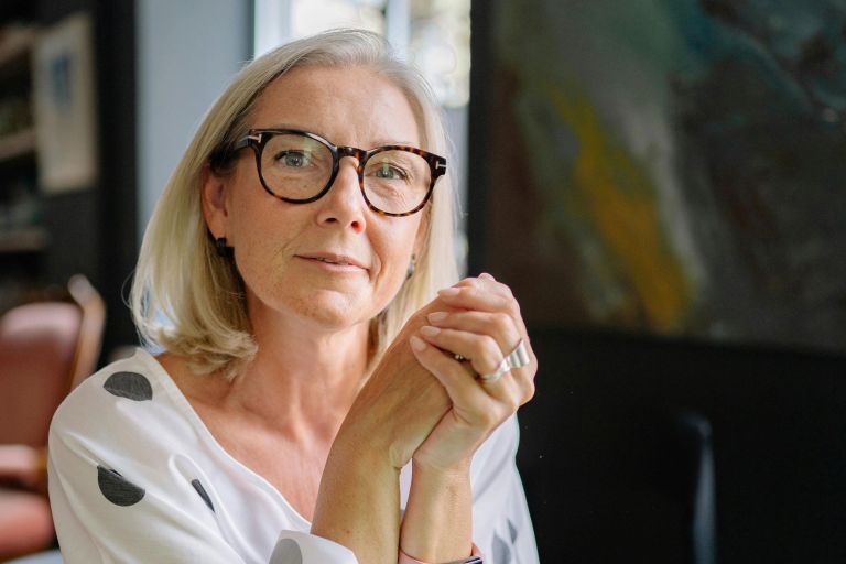 A middle-aged woman sat at a laptop