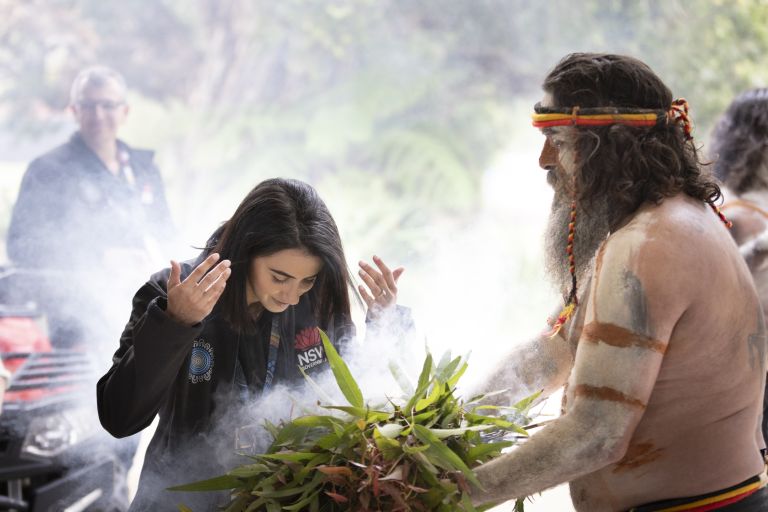 A NSW Government staffer washing the smoke of s moke ceremony over them